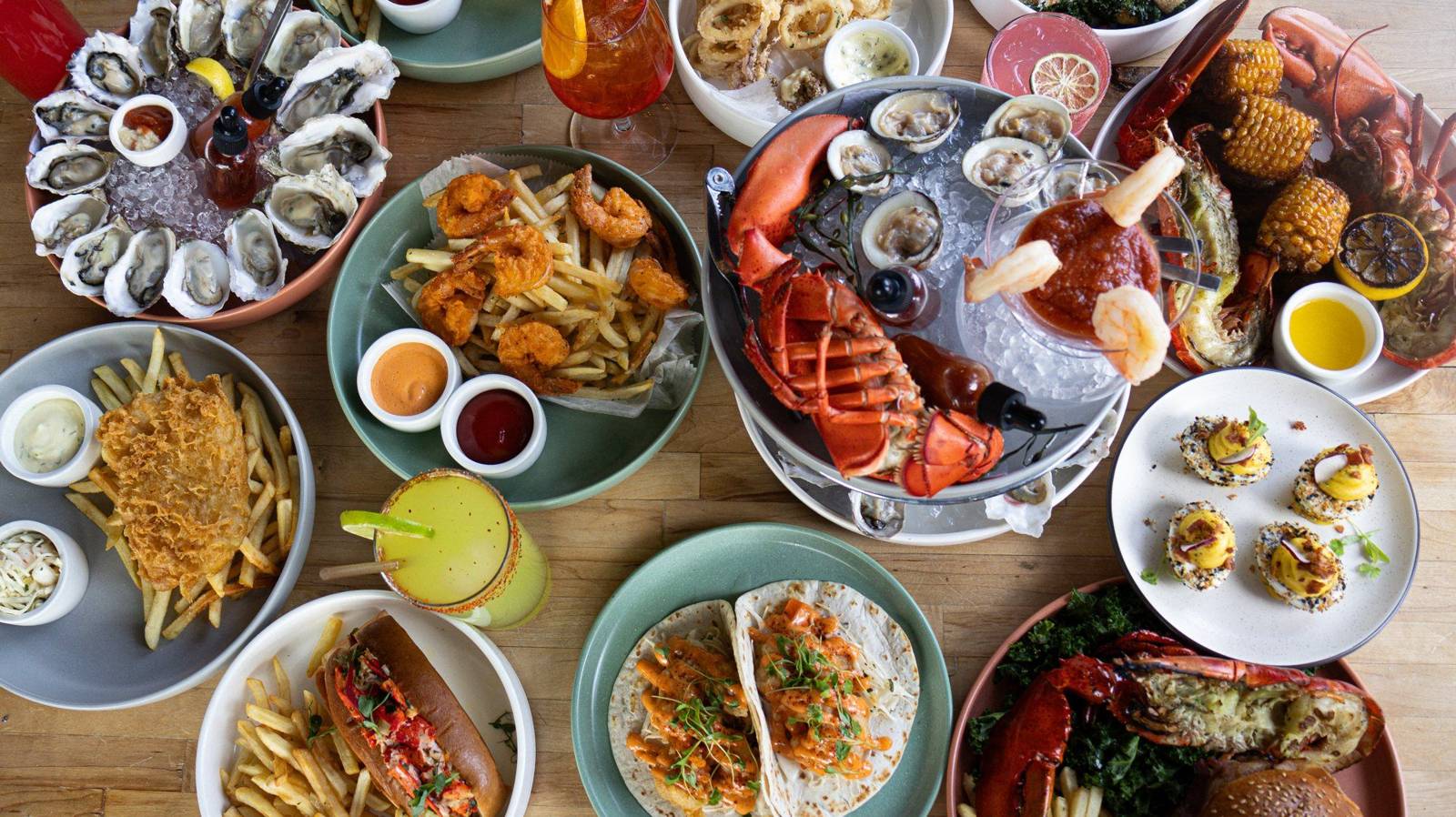 Sea Wolf catering spread: oysters on ice, lobster, ceviche, tacos, wings and fries